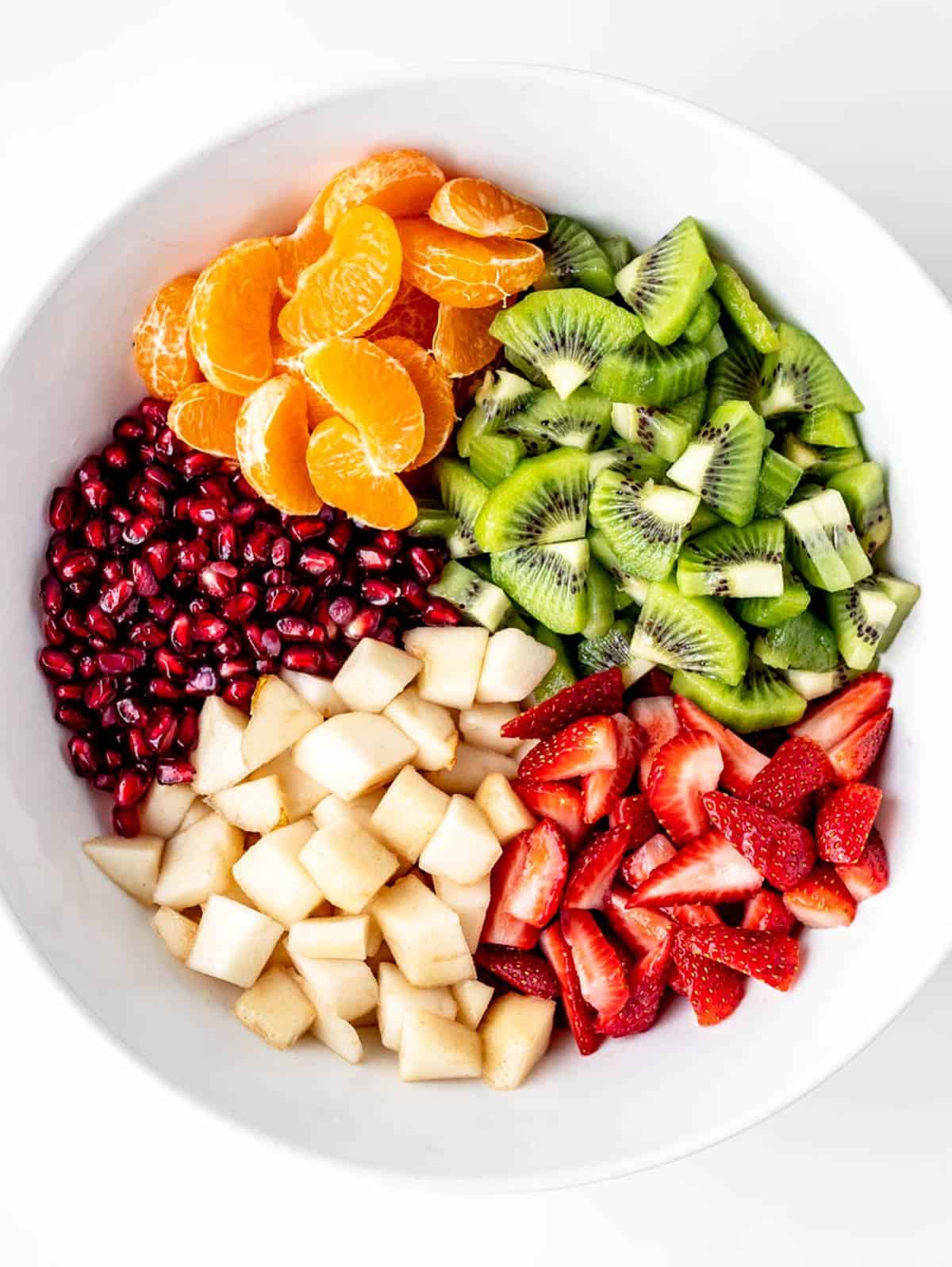 A large serving bowl with the fruit displayed in sections for easy Christmas fruit salad.