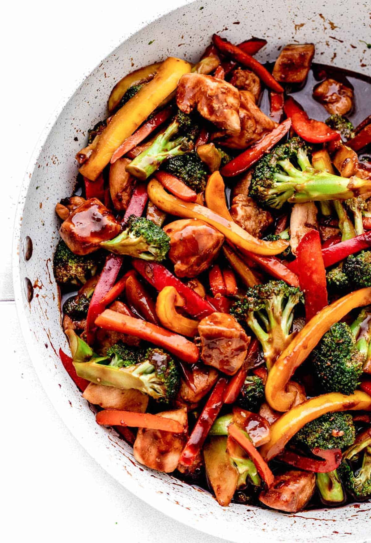 A closeup of healthy chicken stir fry in a frying pan.
