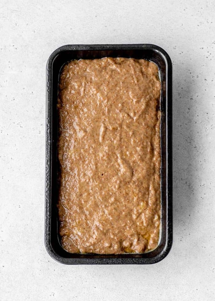 A 9x5 loaf pan filled with banana bread batter.
