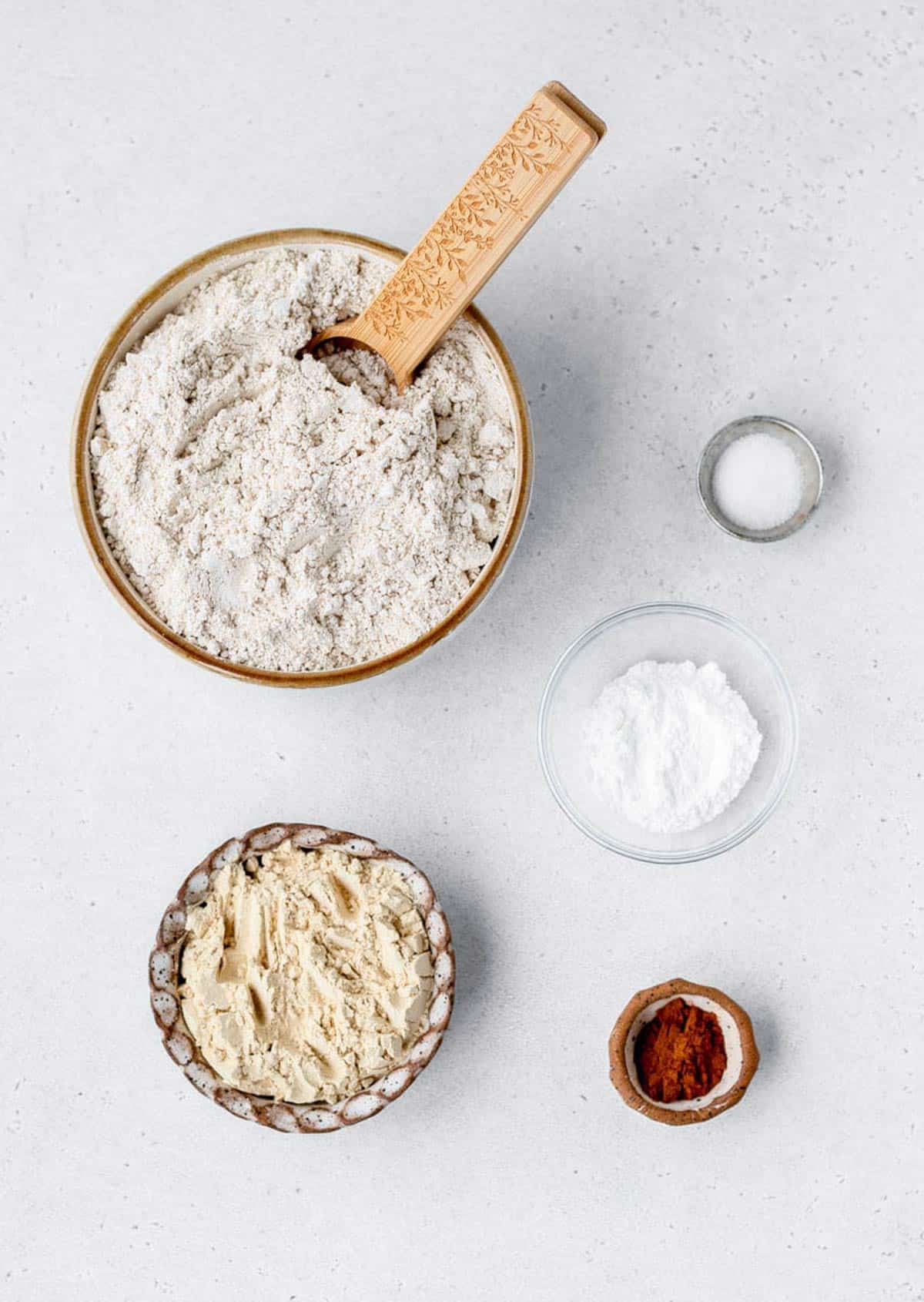 The ingredients for protein pancake mix recipe, including oat flour, vanilla protein powder, cinnamon, salt and baking powder.
