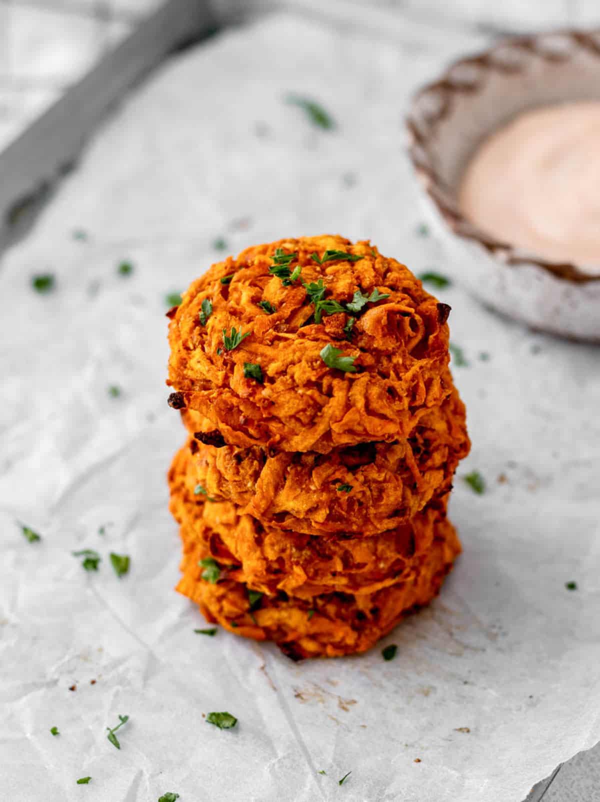 A stack of four baked sweet potato fritters.