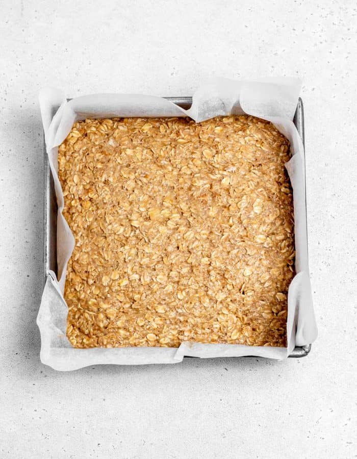 The banana oatmeal mixture pressed into a square pan.