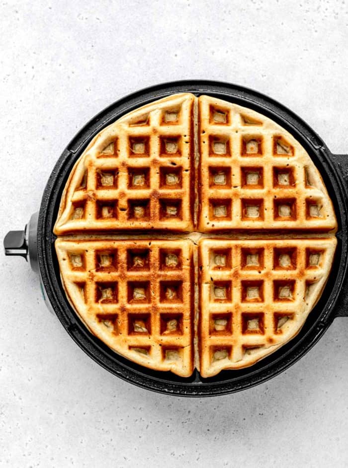 A waffle iron with a cooked high protein waffle.