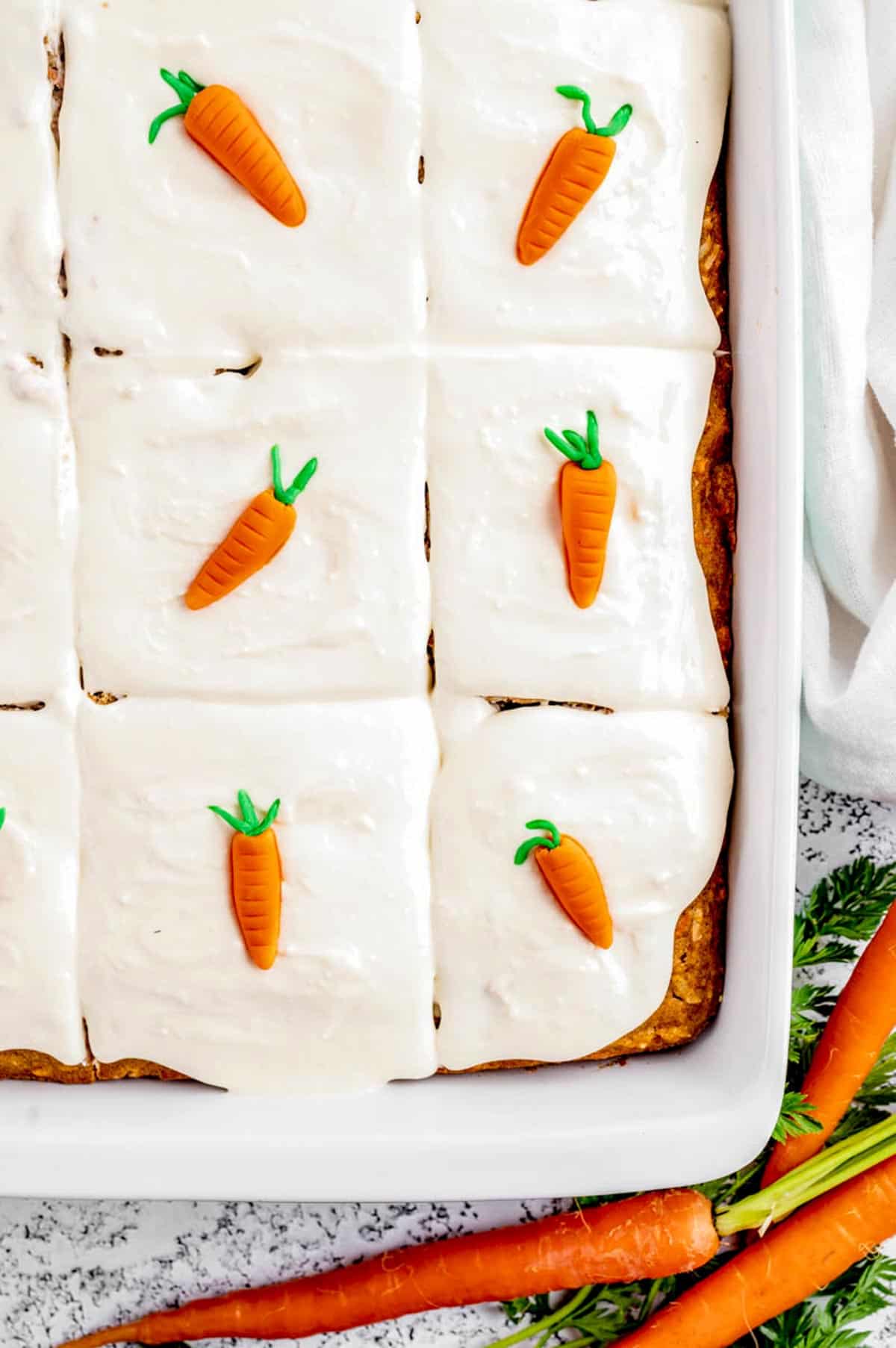 A close up image of the carrot cake with cute little carrot toppers.