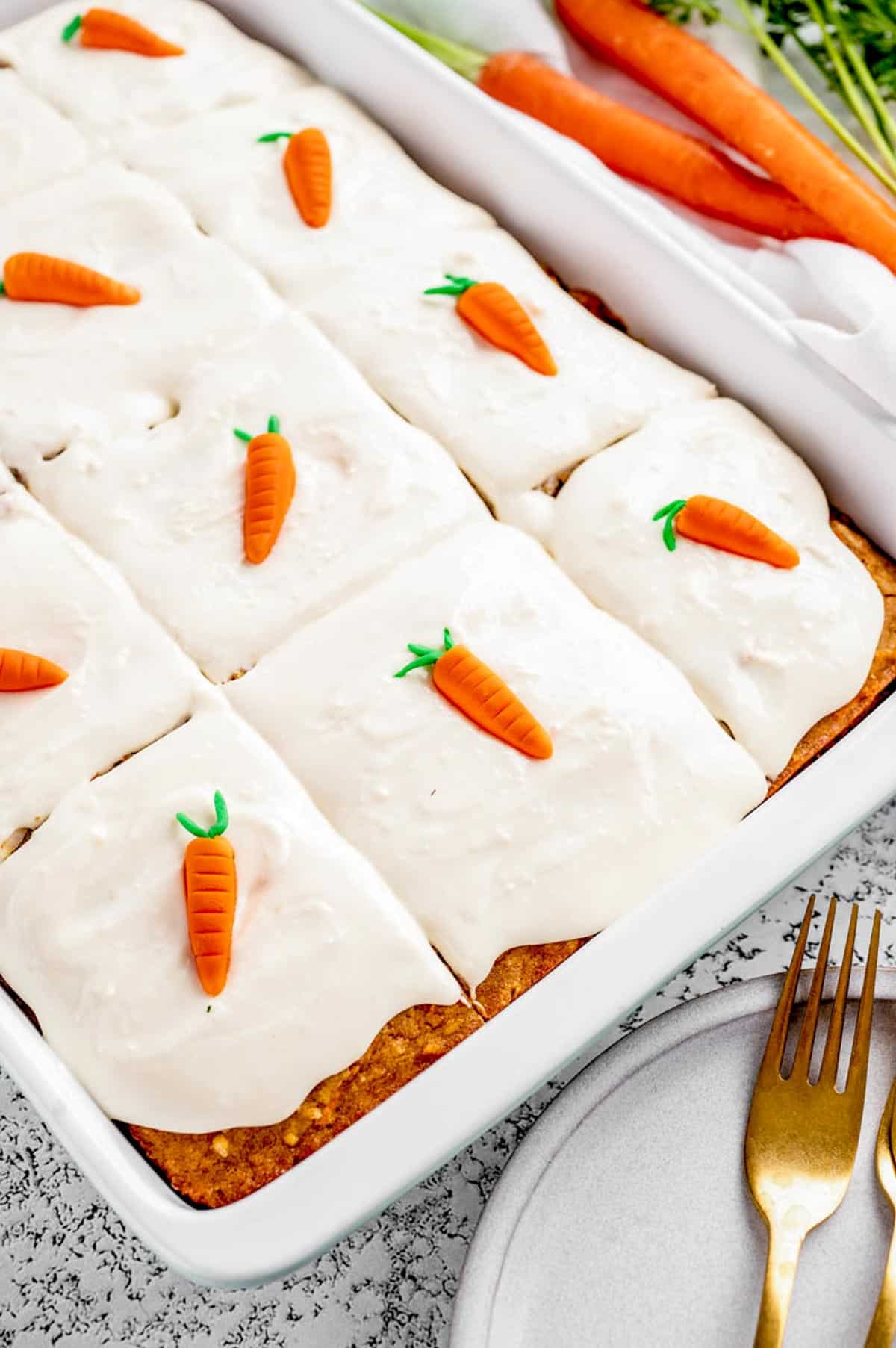 A side shot of healthy carrot cake sliced into pieces in the baking pan.
