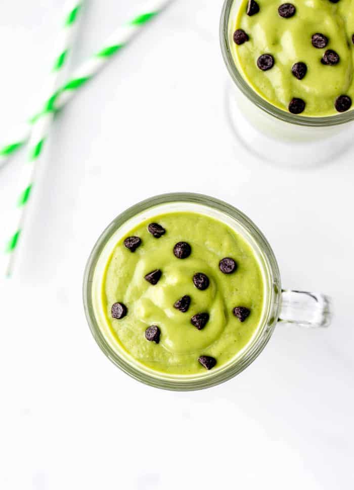 An overhead shot of two healthy shamrock shakes topped with chocolate chips.