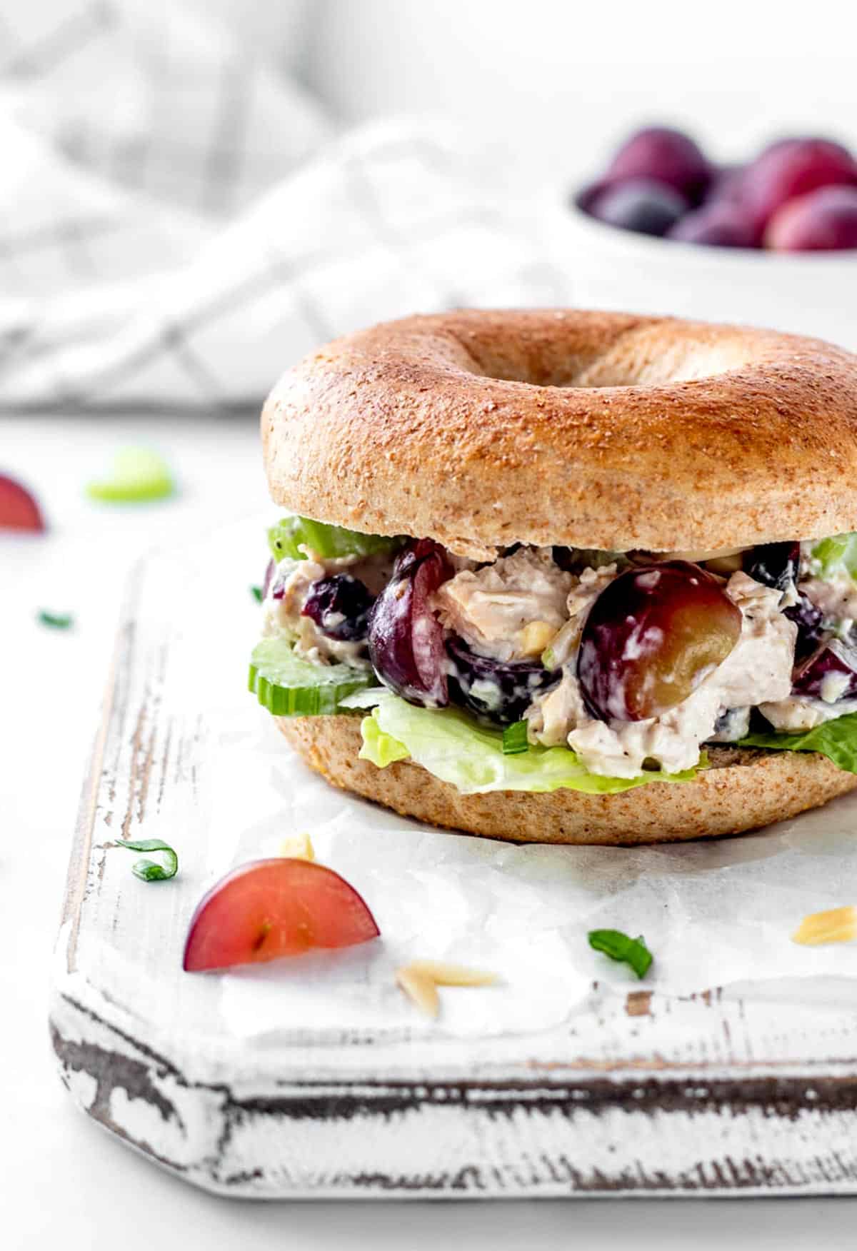 The healthy chicken salad with grapes and almonds on a bagel with lettuce.